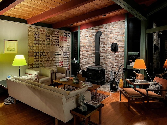 93 Eaton Point Rd, Deer Isle, ME 04627 - living room with wood-type flooring, a wood stove, wooden ceiling with exposed beams, and brick wall
