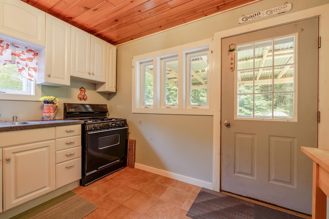 38 Johnson Cove Rd, Otis, ME 04605 - kitchen with black gas range, wooden ceiling, dark countertops, white cabinetry, and light tile patterned floors