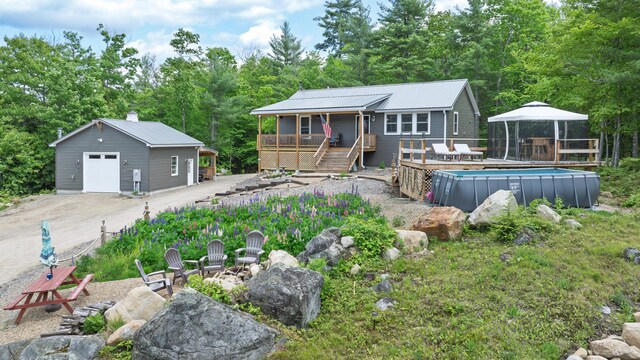 580 Spring St, Brownfield, ME 04010 - view of front of house with a garage, an outdoor pool, a deck, an outdoor structure, and stairway