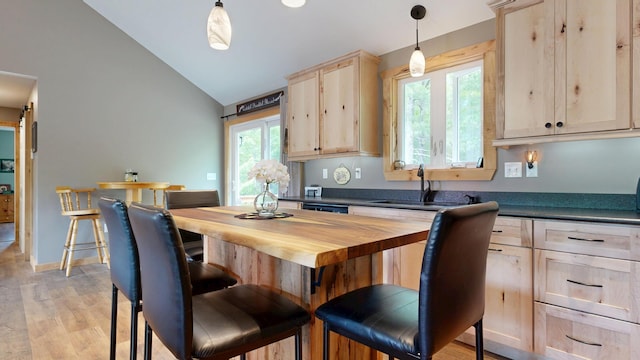 580 Spring St, Brownfield, ME 04010 - kitchen with lofted ceiling, a sink, light brown cabinets, hanging light fixtures, and light wood-style floors