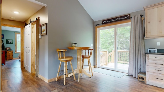 580 Spring St, Brownfield, ME 04010 - dining area with wood finished floors, a barn door, baseboards, and vaulted ceiling