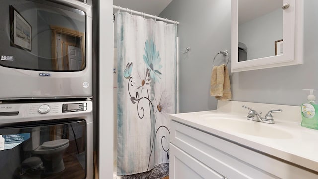 580 Spring St, Brownfield, ME 04010 - bathroom featuring estacked washer and dryer, toilet, vanity, and curtained shower