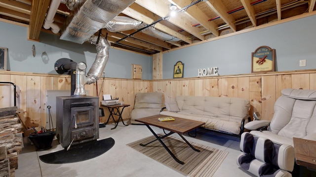 580 Spring St, Brownfield, ME 04010 - living room featuring a wood stove, finished concrete floors, a wainscoted wall, and wooden walls