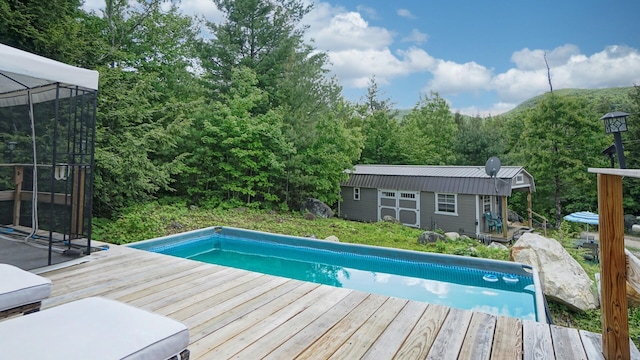 580 Spring St, Brownfield, ME 04010 - outdoor pool featuring an outdoor structure, a deck, an exterior structure, and a forest view