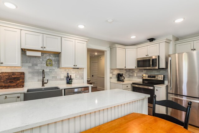 21 Fernald Ave Unit B, York, ME 03909 - kitchen featuring stainless steel appliances, a sink, decorative backsplash, light stone countertops, and recessed lighting