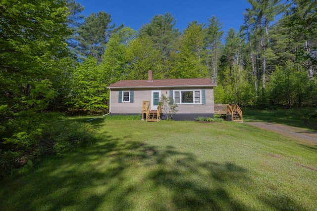 38 Greenridge Way, Jay, ME 04239 - manufactured / mobile home with a forest view, a front yard, a chimney, and a wooden deck