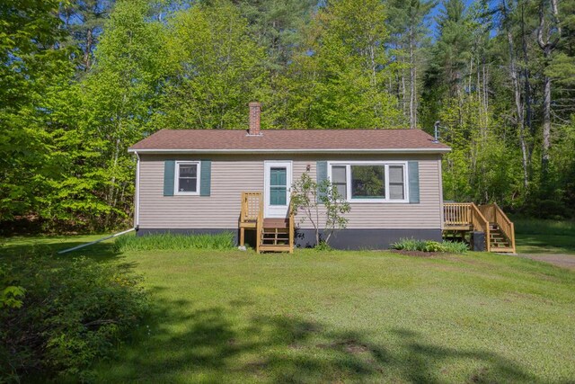 38 Greenridge Way, Jay, ME 04239 - manufactured / mobile home featuring a front lawn, a wooden deck, a wooded view, and a chimney