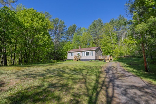 38 Greenridge Way, Jay, ME 04239 - view of front facade featuring a deck, a wooded view, and a front yard