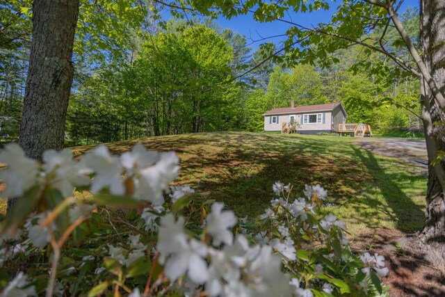 38 Greenridge Way, Jay, ME 04239 - view of green lawn with a view of trees and a deck
