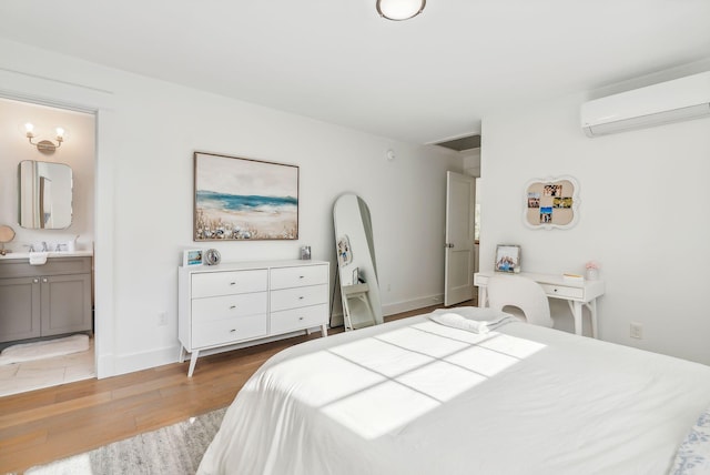 239A Foreside Rd ., Unit Falmouth, ME 04105 - bedroom featuring light wood-style flooring, a wall unit AC, ensuite bath, baseboards, and a sink