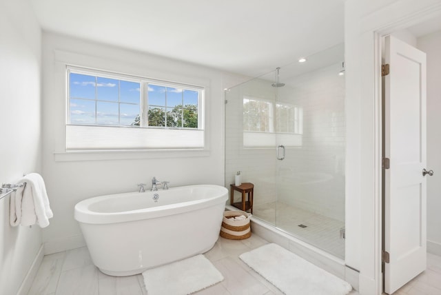 239A Foreside Rd ., Unit Falmouth, ME 04105 - bathroom featuring a shower stall, baseboards, a soaking tub, and marble look tiles