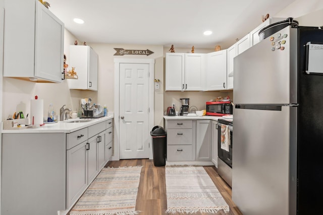 128 Alfred St, Biddeford, ME 04005 - kitchen featuring stainless steel appliances, a sink, light wood-type flooring, light countertops, and recessed lighting