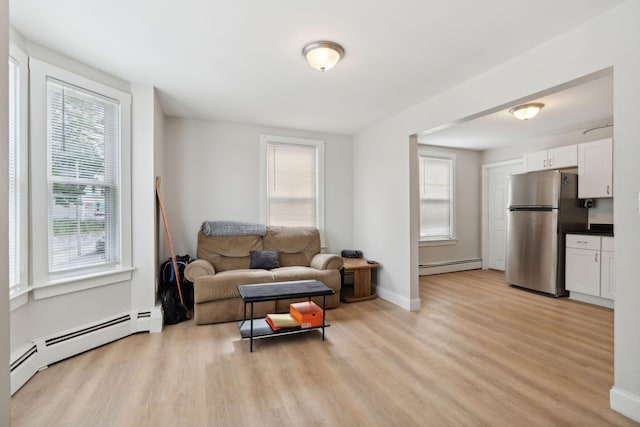 128 Alfred St, Biddeford, ME 04005 - living room with a baseboard heating unit, light wood-type flooring, and baseboards