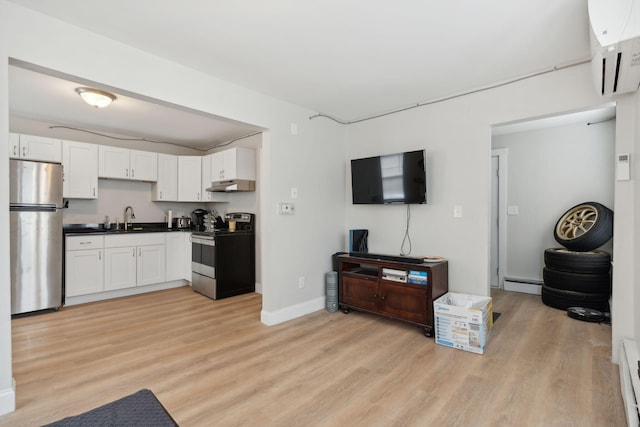 128 Alfred St, Biddeford, ME 04005 - kitchen featuring appliances with stainless steel finishes, under cabinet range hood, a wall mounted AC, a sink, and dark countertops