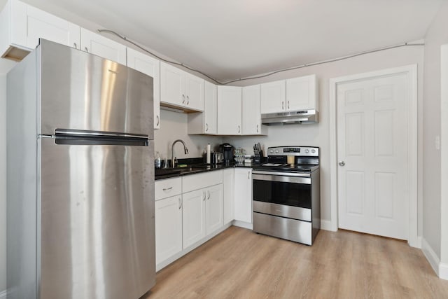 128 Alfred St, Biddeford, ME 04005 - kitchen with stainless steel appliances, under cabinet range hood, light wood-style floors, and dark countertops