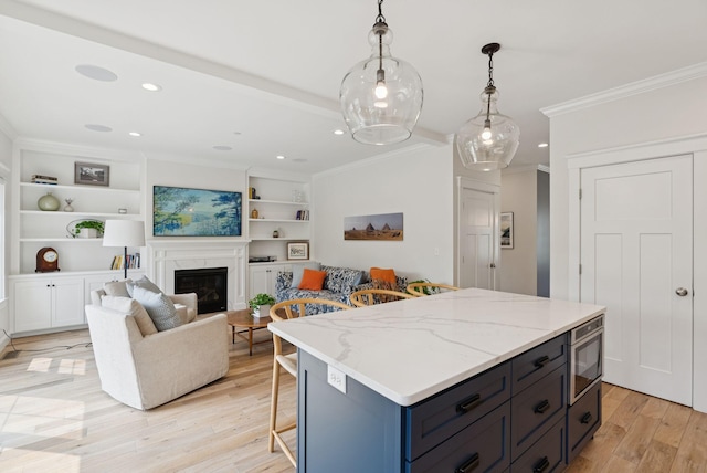 25 Benjamin Way, Portland, ME 04102 - kitchen with ornamental molding, light wood-style flooring, a kitchen breakfast bar, hanging light fixtures, and a glass covered fireplace