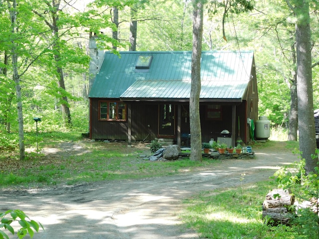 51 Pond Rd, Abbot, ME 04406 - view of front of house with metal roof, covered porch, and a chimney