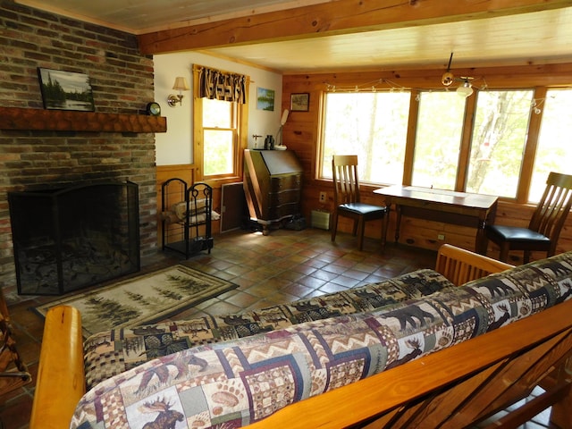 51 Pond Rd, Abbot, ME 04406 - living room featuring tile patterned floors, wood walls, beam ceiling, a wainscoted wall, and a brick fireplace