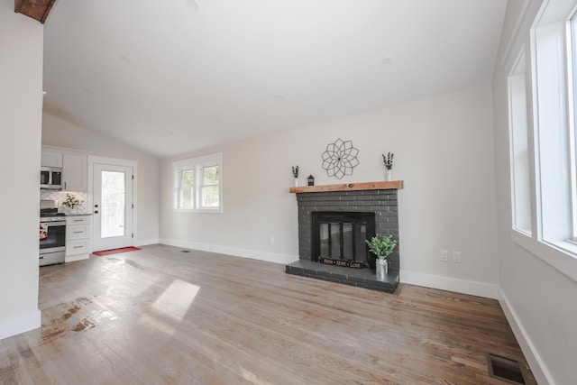1 Knowlton Rd, Nashua, NH 03063 - unfurnished living room with a brick fireplace, light wood-style flooring, vaulted ceiling, and baseboards