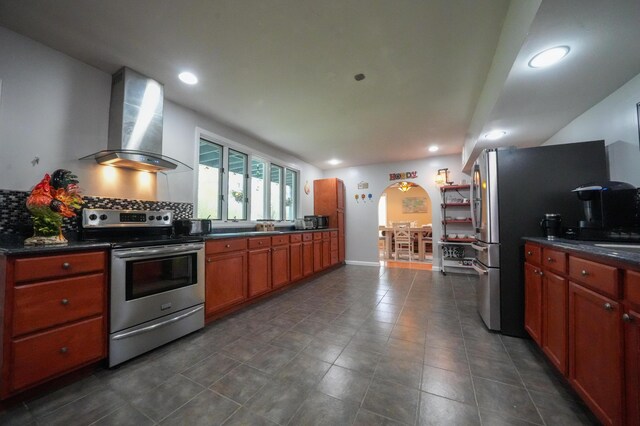 50 Water St, Howland, ME 04448 - kitchen featuring appliances with stainless steel finishes, wall chimney range hood, dark countertops, arched walkways, and recessed lighting