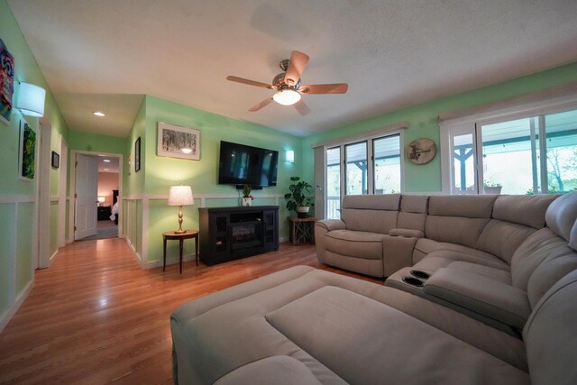 50 Water St, Howland, ME 04448 - living area featuring a ceiling fan, wood finished floors, a glass covered fireplace, and recessed lighting
