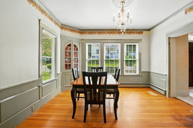 11 Pine Ave, Livermore Falls, ME 04254 - dining room with a chandelier, a decorative wall, wood finished floors, ornamental molding, and plenty of natural light