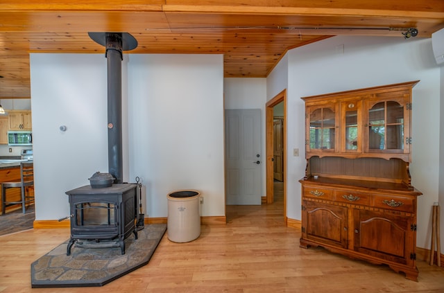 177 Meadow Ln, Smithfield, ME 04978 - living area with a wood stove, light wood-style floors, wood ceiling, and an AC wall unit
