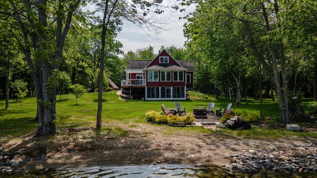 177 Meadow Ln, Smithfield, ME 04978 - rear view of house with a fire pit, a lawn, a sunroom, and a deck with water view