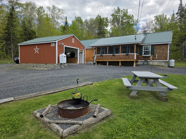25 Oak Ridge Rd, Shirley, ME 04485 - back of house featuring a fire pit, a lawn, metal roof, and an outdoor structure