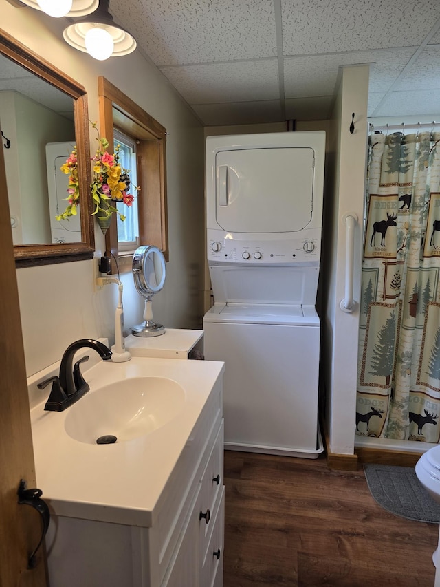 25 Oak Ridge Rd, Shirley, ME 04485 - bathroom featuring stacked washing machine and dryer, a paneled ceiling, vanity, wood finished floors, and curtained shower