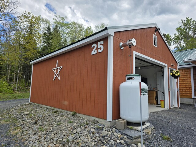 25 Oak Ridge Rd, Shirley, ME 04485 - view of home's exterior with an outbuilding, a garage, metal roof, and a surveillance system