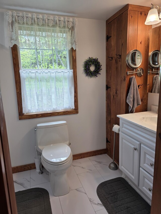 25 Oak Ridge Rd, Shirley, ME 04485 - half bathroom with marble look tiles, vanity, toilet, and baseboards