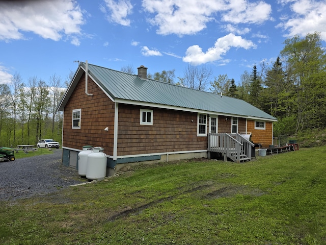 25 Oak Ridge Rd, Shirley, ME 04485 - rear view of house featuring a chimney, metal roof, and a yard