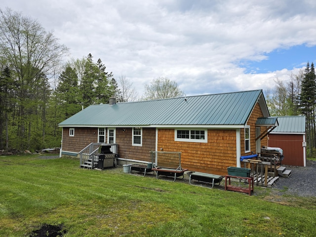 25 Oak Ridge Rd, Shirley, ME 04485 - back of house with metal roof, a lawn, and a chimney