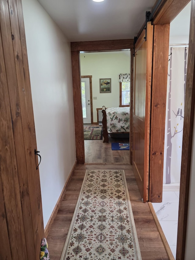 25 Oak Ridge Rd, Shirley, ME 04485 - hall featuring baseboards, wood finished floors, and a barn door