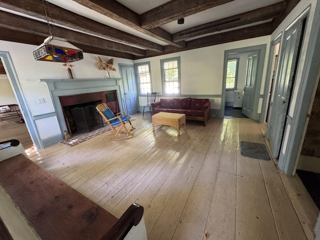 186 Bridgton Rd, Sebago, ME 04029 - living area featuring light wood-style floors, a fireplace with flush hearth, and beam ceiling