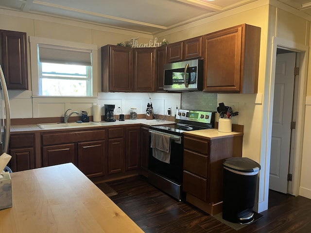 6 High St, Waterville, ME 04901 - kitchen featuring stainless steel appliances, a sink, light countertops, dark wood-type flooring, and crown molding