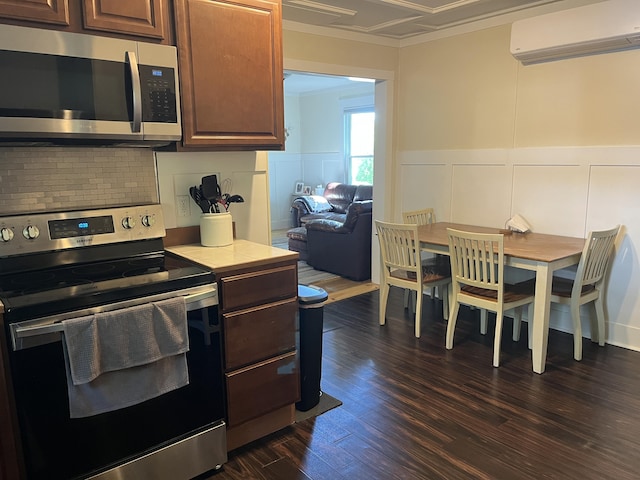 6 High St, Waterville, ME 04901 - kitchen with stainless steel appliances, a wall mounted air conditioner, crown molding, light countertops, and dark wood-type flooring