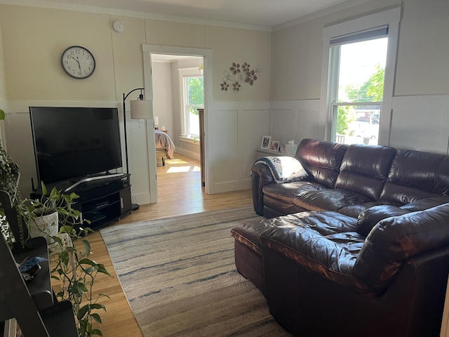 6 High St, Waterville, ME 04901 - living room with ornamental molding, light wood-style flooring, a decorative wall, and a wainscoted wall