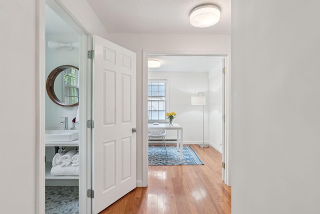 1 Dresden Ct Unit 1, Portland, ME 04103 - corridor with a sink, light wood-style flooring, and baseboards