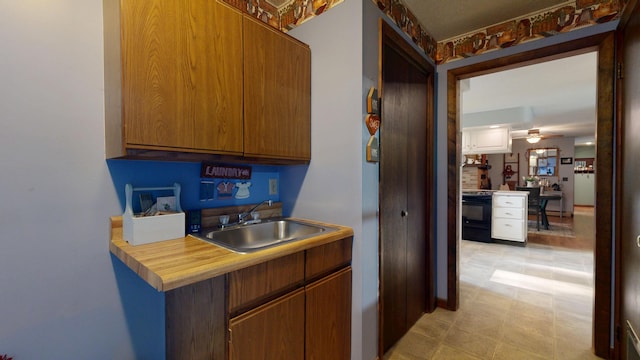 76 Parkview Ave, Livermore Falls, ME 04254 - kitchen featuring stove, ceiling fan, light countertops, and brown cabinets
