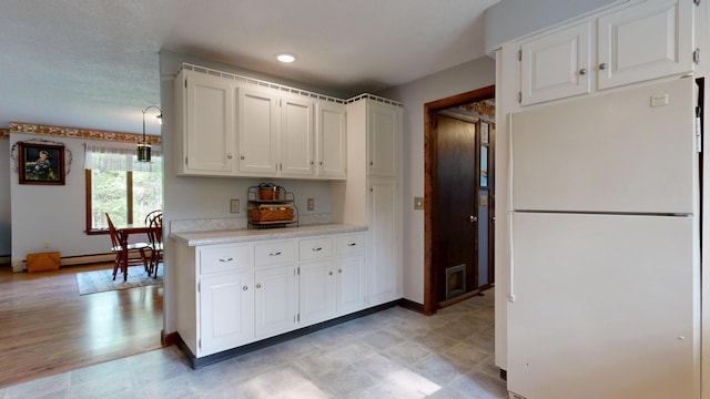 76 Parkview Ave, Livermore Falls, ME 04254 - kitchen featuring freestanding refrigerator, light countertops, white cabinets, and a baseboard heating unit
