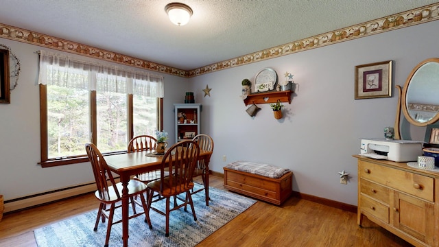 76 Parkview Ave, Livermore Falls, ME 04254 - dining room featuring light wood-style floors, a textured ceiling, and a baseboard heating unit