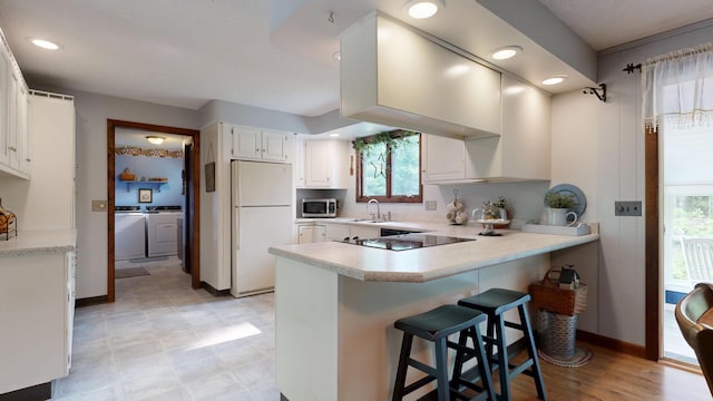 76 Parkview Ave, Livermore Falls, ME 04254 - kitchen with freestanding refrigerator, stainless steel microwave, a peninsula, black electric cooktop, and light countertops