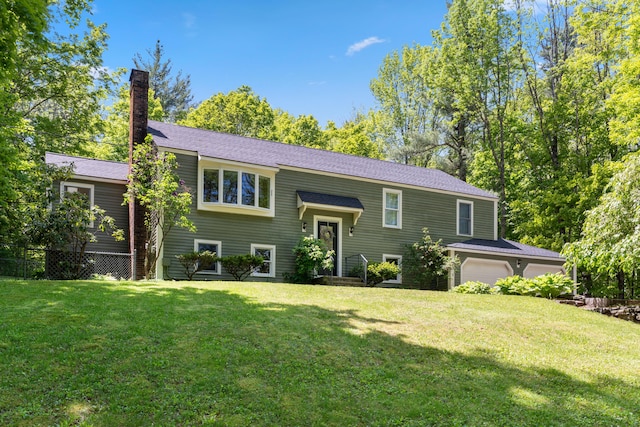 3 Wilson Ln, Saco, ME 04072 - bi-level home featuring a front lawn, a chimney, and an attached garage