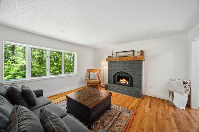 3 Wilson Ln, Saco, ME 04072 - living room featuring baseboards, a fireplace, wood finished floors, and a textured ceiling