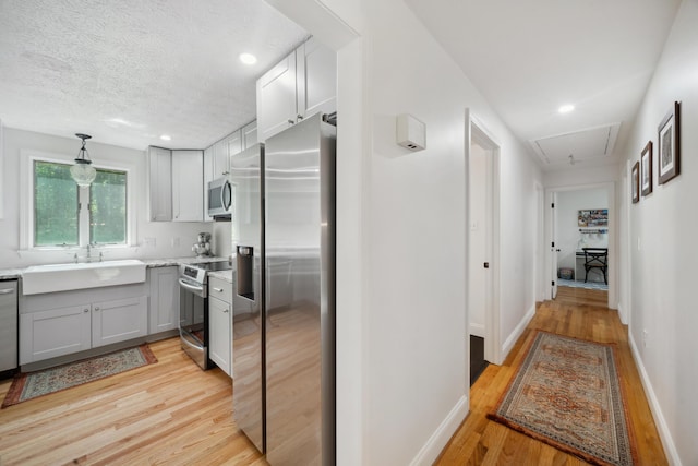 3 Wilson Ln, Saco, ME 04072 - kitchen with appliances with stainless steel finishes, a sink, light wood-type flooring, gray cabinets, and a textured ceiling