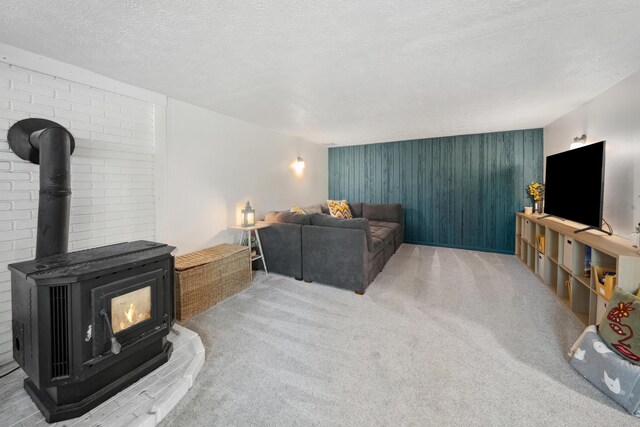 3 Wilson Ln, Saco, ME 04072 - carpeted living area featuring a wood stove, a textured ceiling, and an accent wall