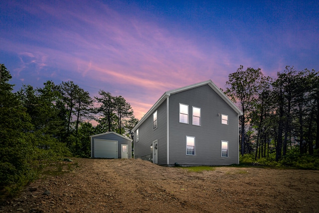 711 Newfield Rd, Shapleigh, ME 04076 - property exterior at dusk with an outbuilding, a garage, and dirt driveway