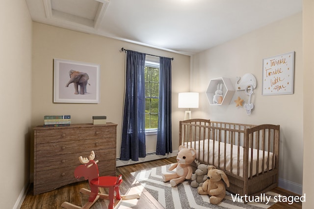711 Newfield Rd, Shapleigh, ME 04076 - bedroom with wood finished floors, baseboards, a nursery area, and a baseboard heating unit
